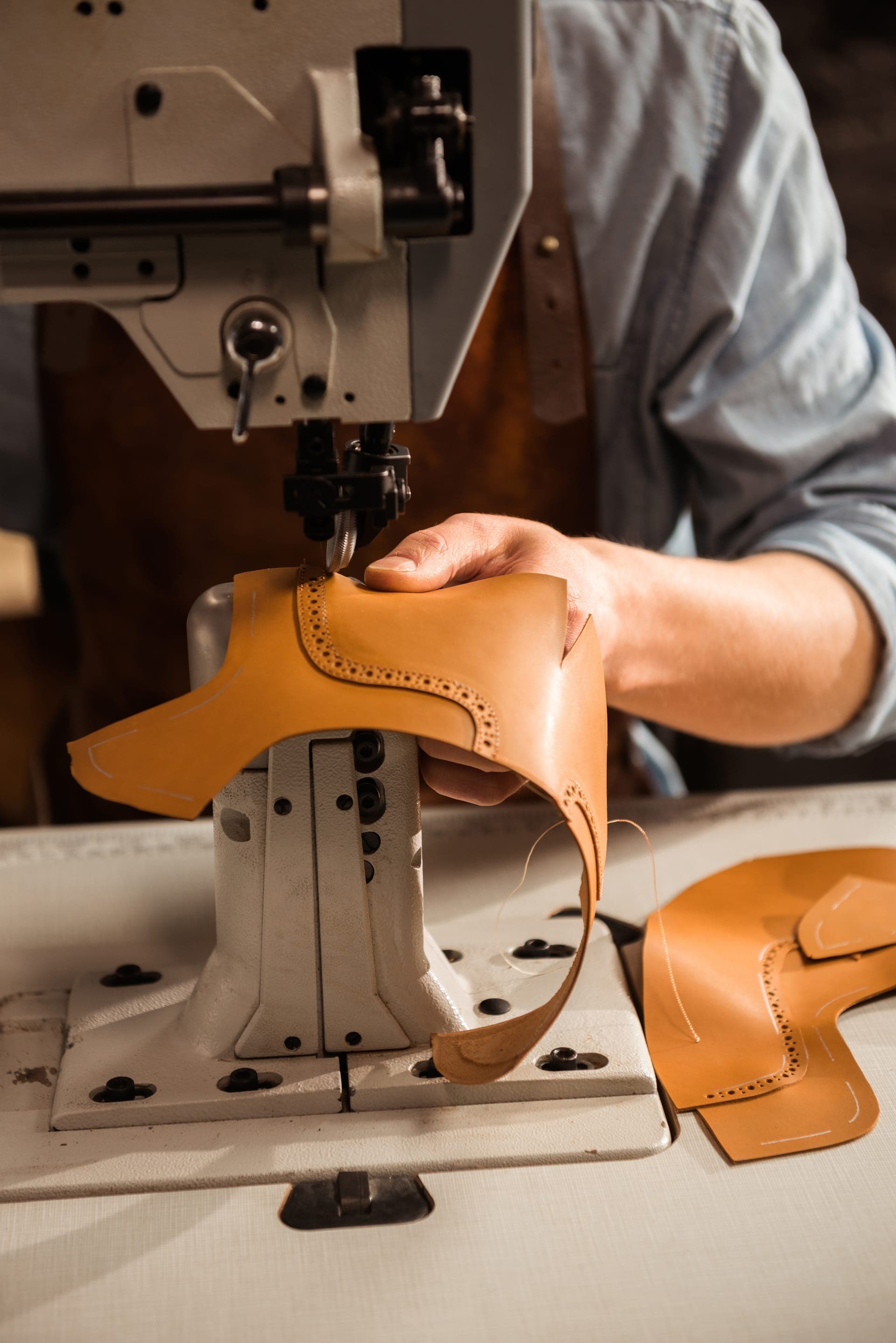 Shoemaker using a sewing machine for leather goods