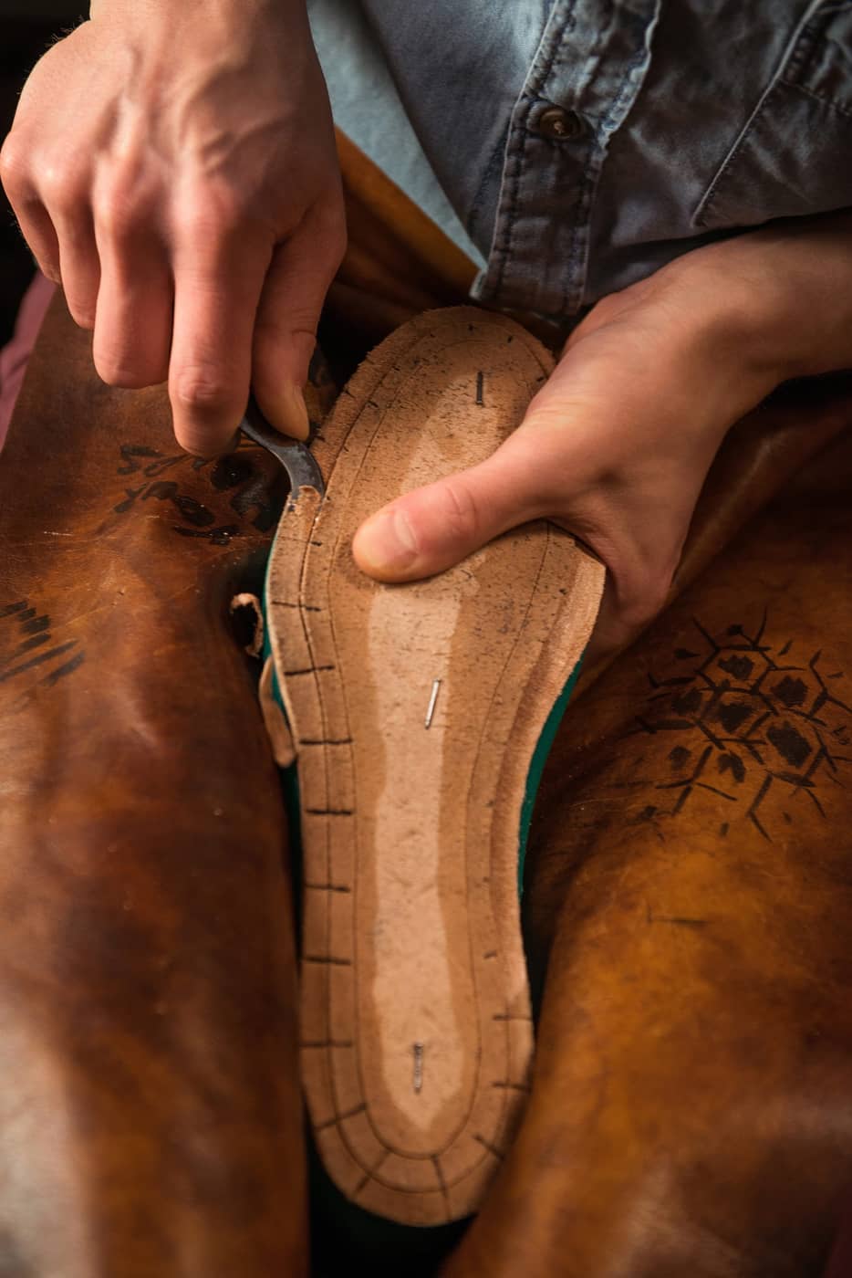 Shoemaker crafting leather footwear in a workshop